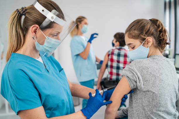 Doctor vaccinating girl Injecting COVID 19 vaccine into patient's arm